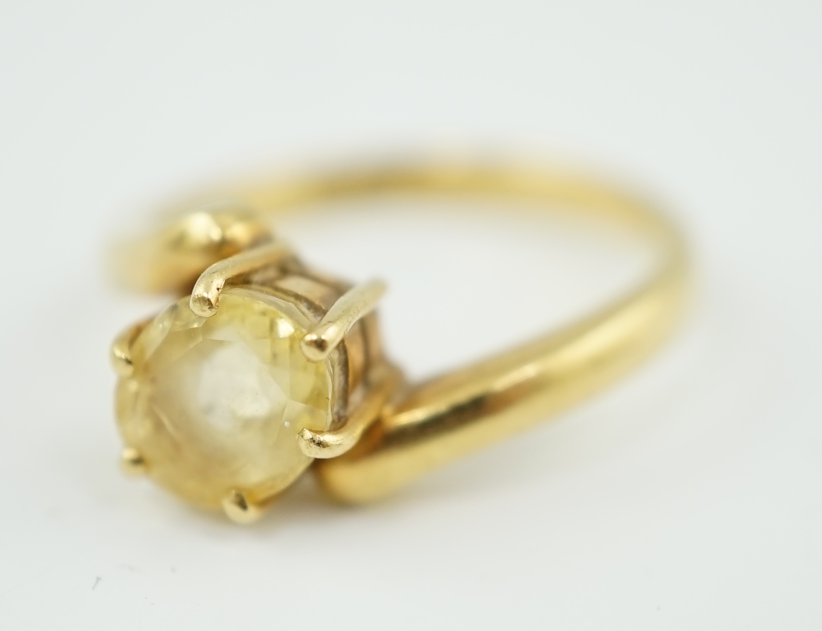 An 18k gold and solitaire oval cut yellow sapphire